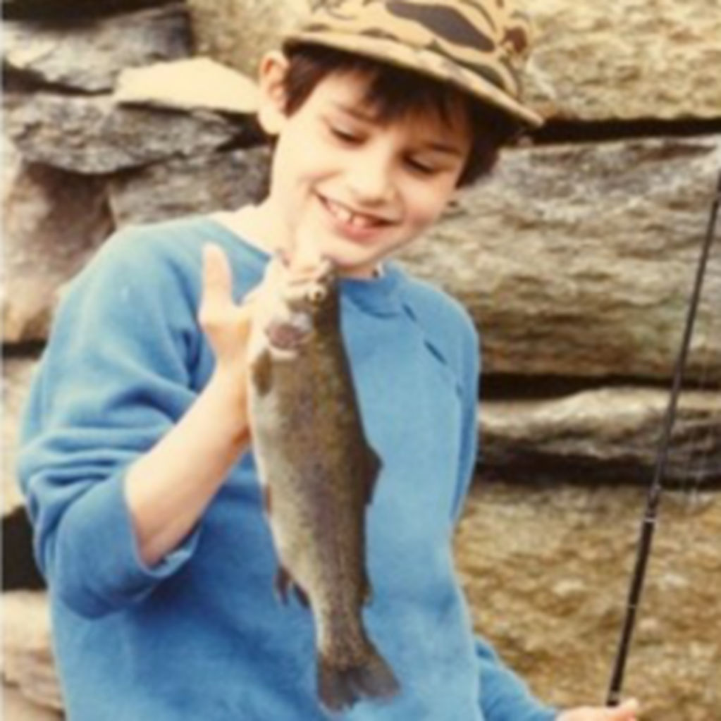 Jeff as a boy, holding up a trout he caught.