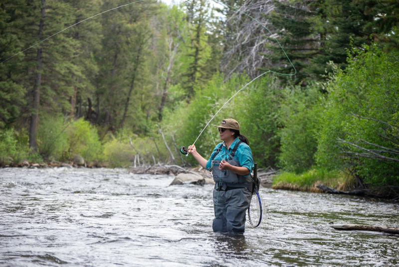 Erica Nelson fishing while wading in a river