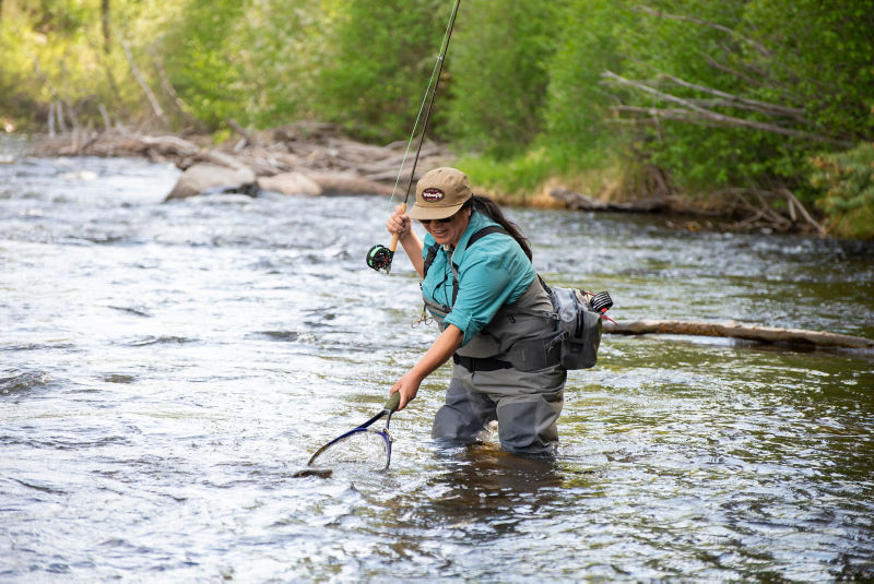 Erica Nelson snagging her catch in a net while fishing