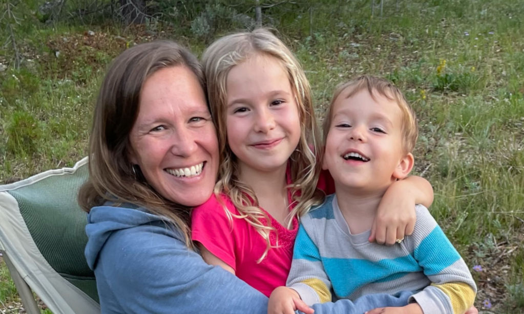 Laura Schaffer and her two children in a smiling embrace.