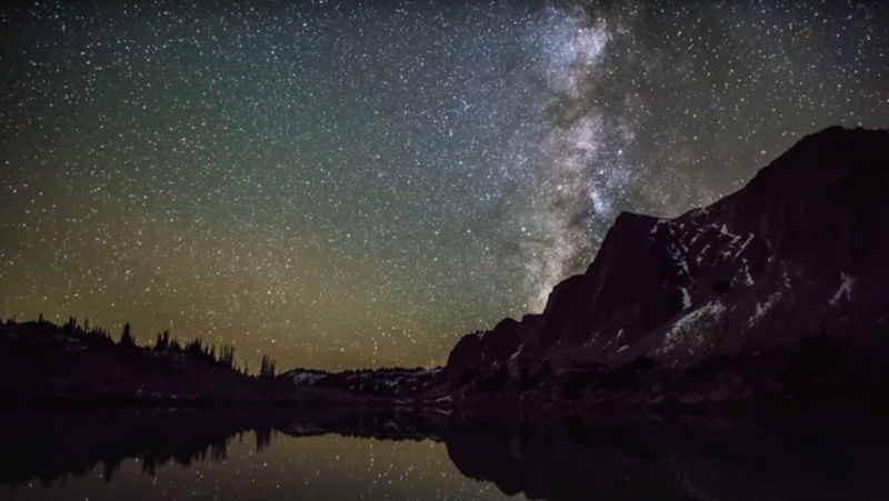 Mountains and a lake at night with tons of stars and the milky way showing in the night sky