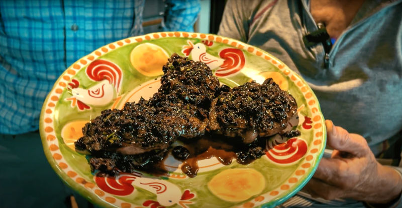 A colorful plate of cooked duck breast with a rich port sauce