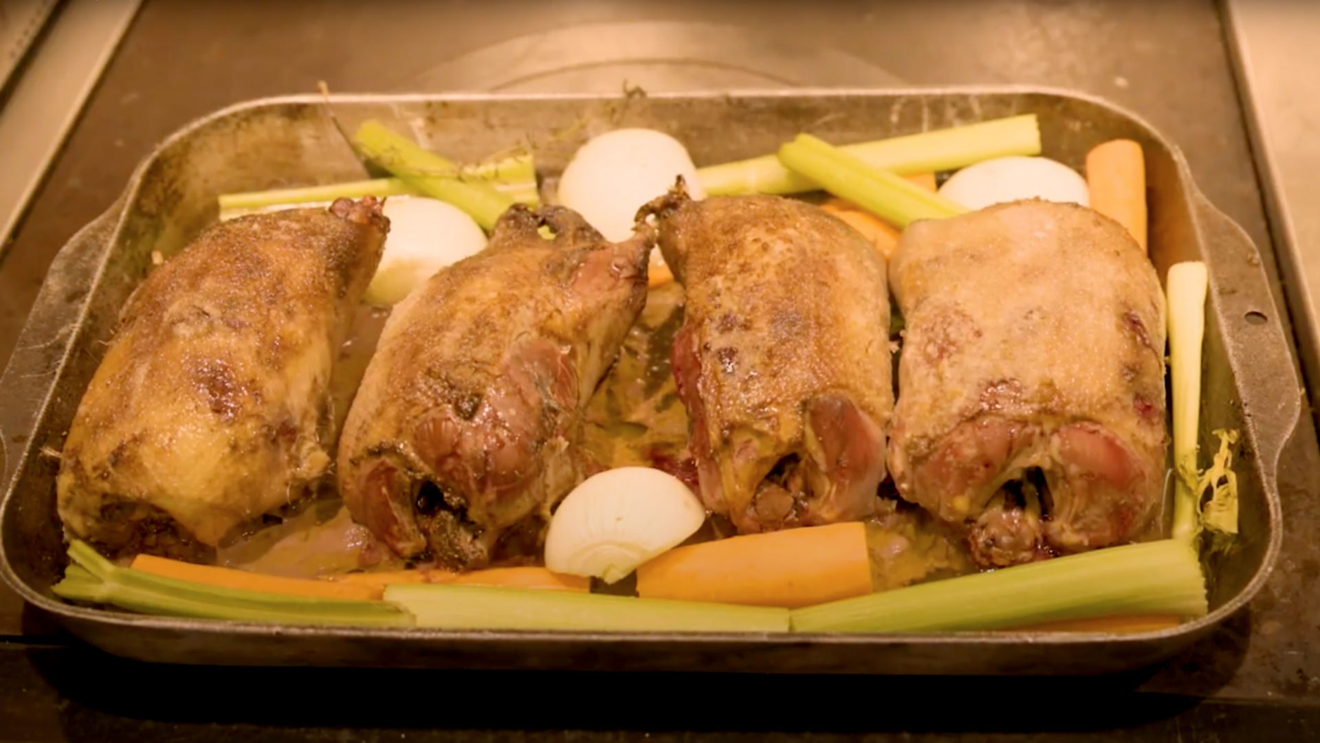 A close-up of roasted ducks in the roasting pan