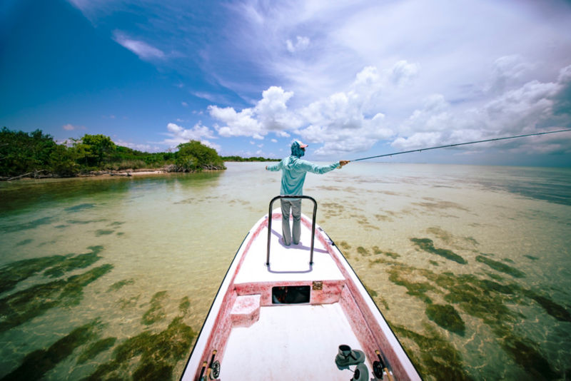 An angler casting from the bow of a boat on the Flats.