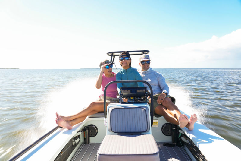 Benny Blanco's family in a motorboat smiling as they speed over the ocean.