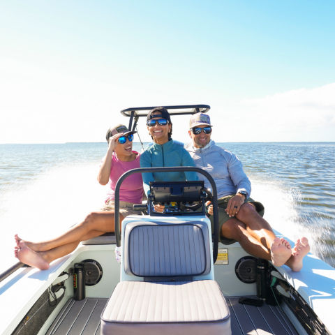 Benny Blanco's family in a motorboat smiling as they speed over the ocean.
