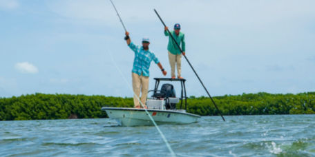 Two men on a boat fishing in blue waters