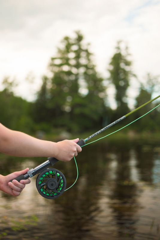 A close-up of two hands holding a fly rod.