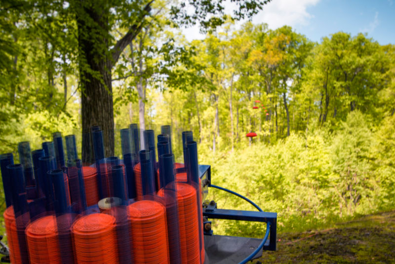 Bright orange clays being shot out of a machine