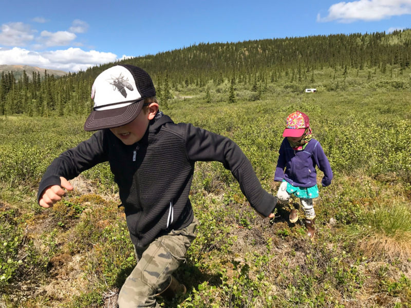 Two children run through scrublands in Alaska.