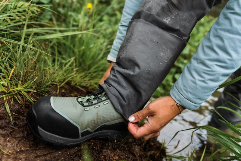 Two hands adjust waders over Ultralight boots.