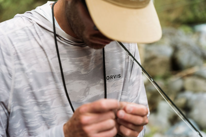 A close-up of a person's gray and white sun protective shirt.