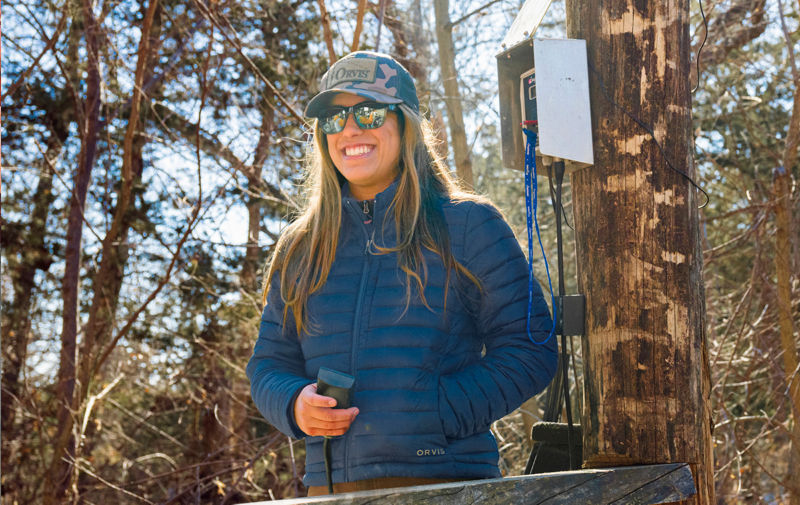 A portrait of product designer Natalie Cullum in the woods wearing a Drift jacket