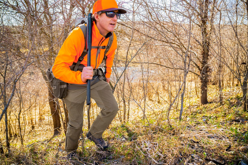 A hunter in a PRO Jacket makes his way through tall briars.