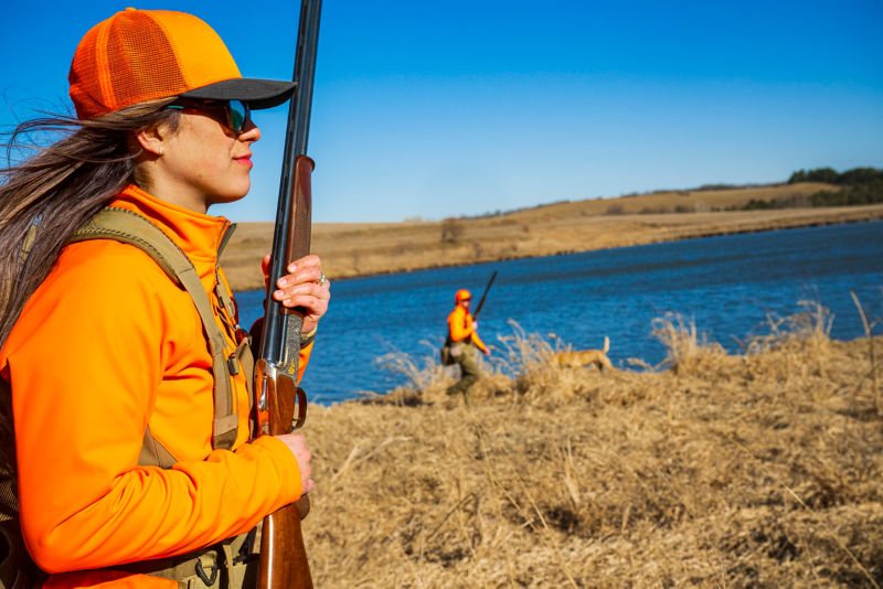 A wingshooter hunting in blaze orange jacket, vest, and hat.