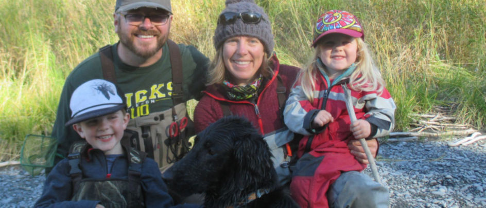 Nelli Williams with her family and dog on a rocky shore.