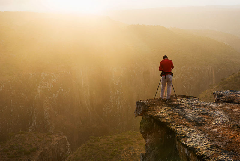 A photographer taking photos off a cliff.