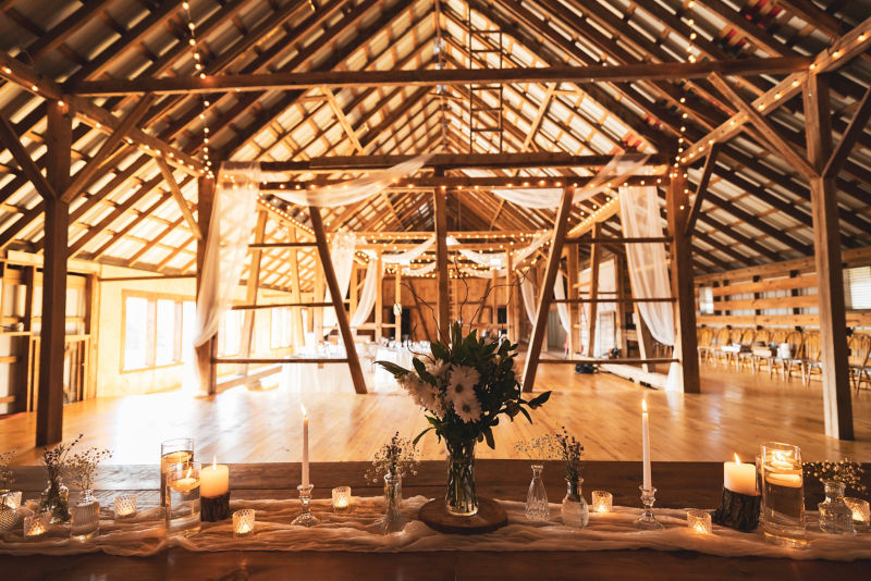 Inside the rustic wedding barn showing the lighting and table settings.