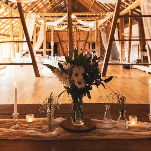 Inside the rustic wedding barn showing the lighting and table settings.