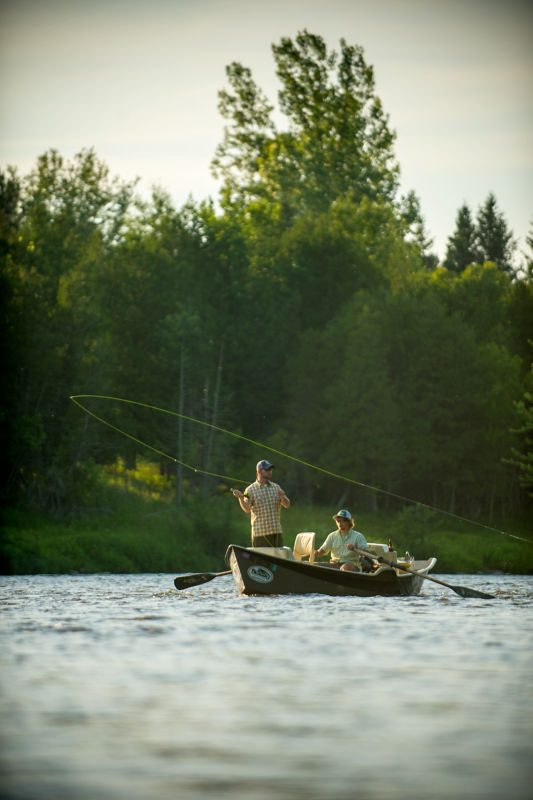Two people fly fishing from a drift boat.
