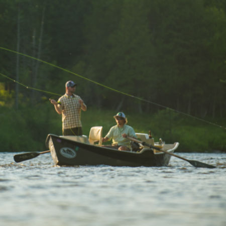Two people fly fishing from a drift boat