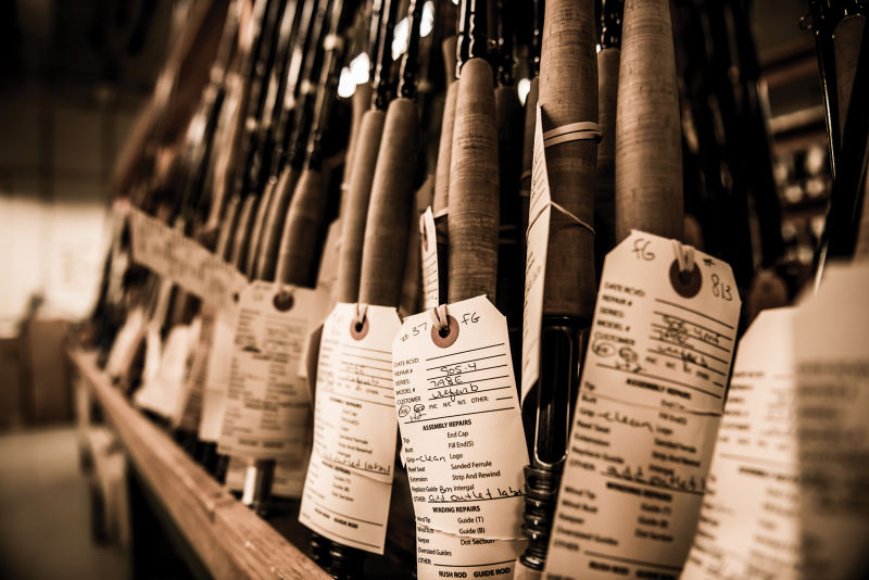 Image of rods in the Orvis factory with work order tags hanging from them.