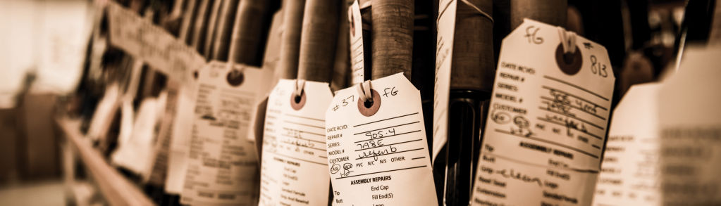 Image of rods in the Orvis factory with work order tags hanging from them.