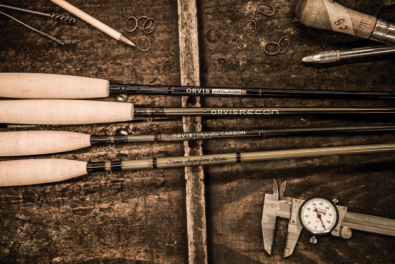 Four Orvis Fly Rods sit on a wooden background.