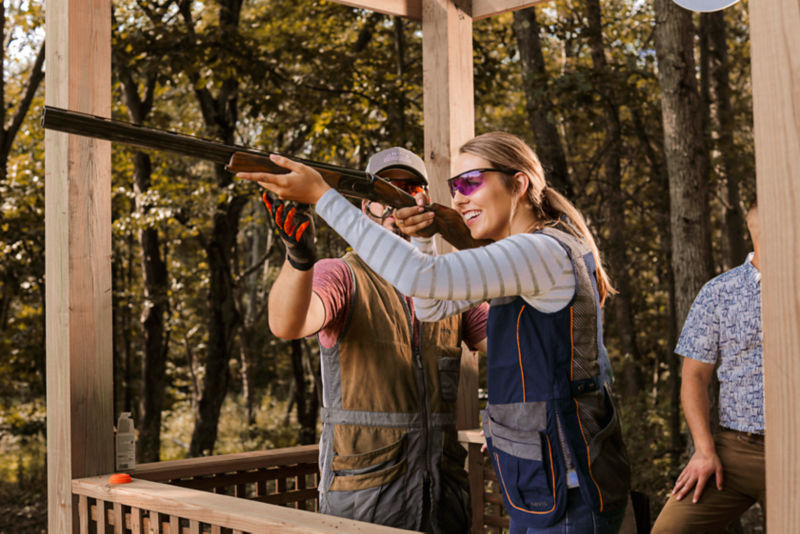 A guide helps a student learn how to adjust her aim with her shotgun.