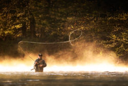 A man casts a spey rod on a river