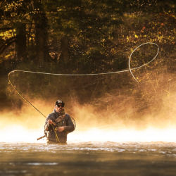 A man casts a spey rod on a river.