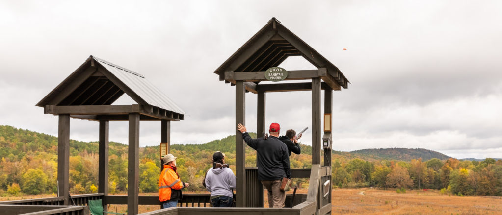 Four people at a shooting stand on a cloudy day