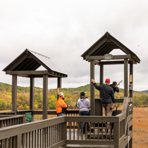 A shooting stand with people watching one hunter