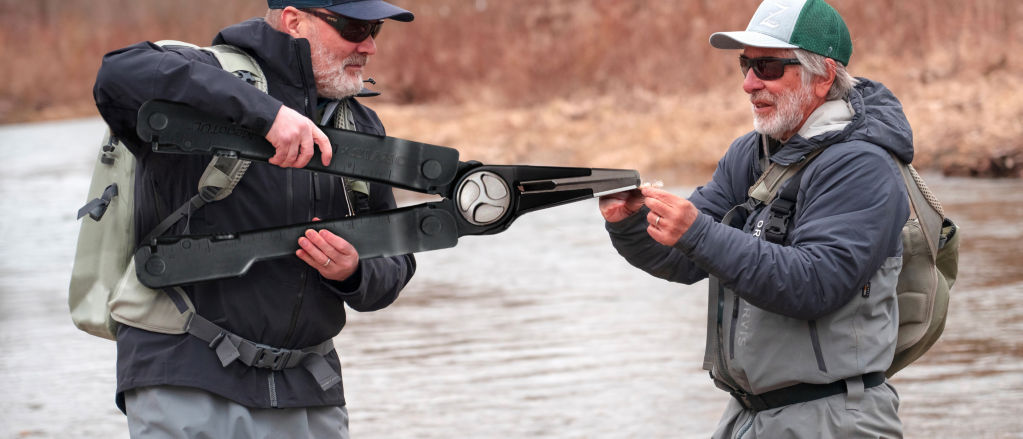 An angler uses a 4 foot MegaTÜL™ to clip a fly held by another angler.