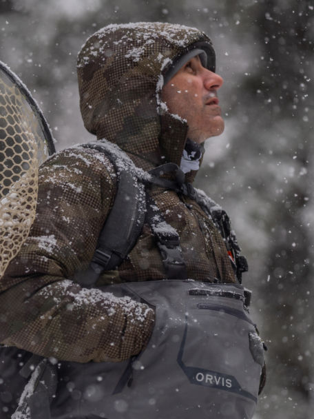Man wears cold weather fishing gear in the snow