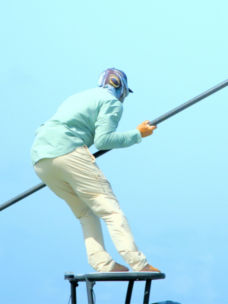 An angler wearing pro fishing gear poles a boat