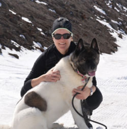 Reenie Benzinger with her dog on a snowy mountainside