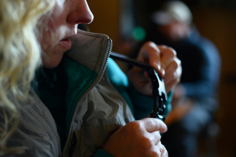 A close-up of an angler snapping up her waders.