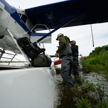 Two men in fishing gear by a float plane