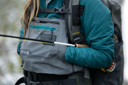 An angler warms their hands in the kangaroo pockets of their PRO waders.