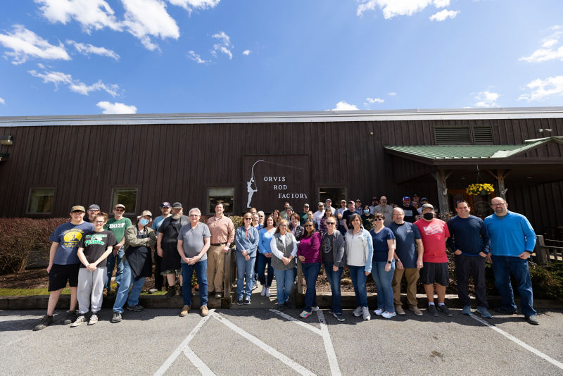 The employees of the Orvis Rod Shop stand outside the factory in the sunshine