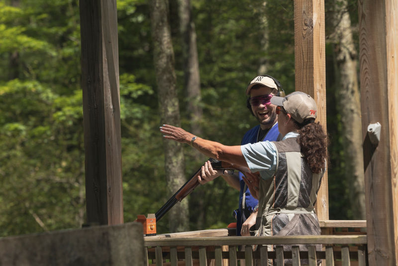 Paula gestures down the range for a laughing student.