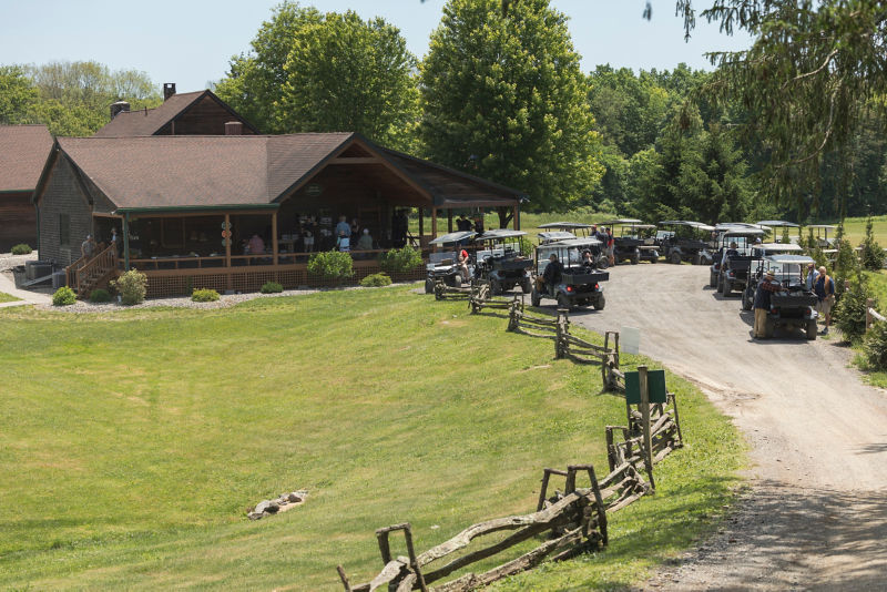 The lodge at Sandanona with a porch full of people and a drive full of golf carts.