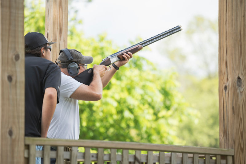 An instructor giving a hunter shooting instruction.