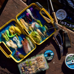 Looking down on a fly box and other fishing supplies