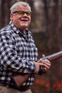 man in a plaid shirt holding a gun