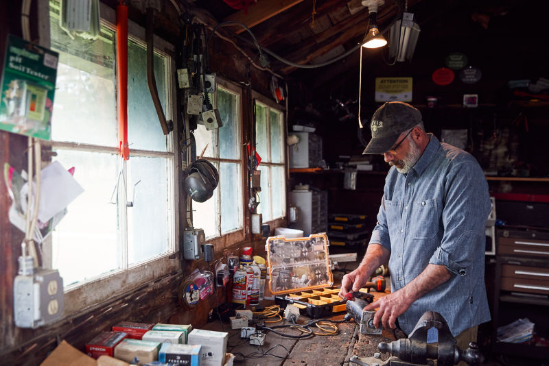 A crowded workshop with a person at the worktable.