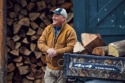 man in front of wood pile