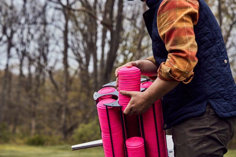 A shooting instructor fills a skeet machine.