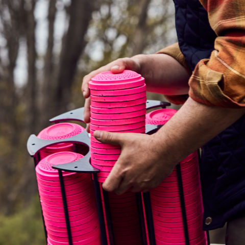 A man holding the machine that houses hot pink clays